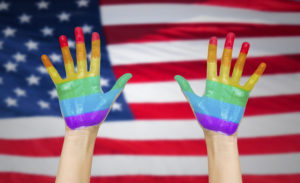 hands painted in rainbow colours and american flag